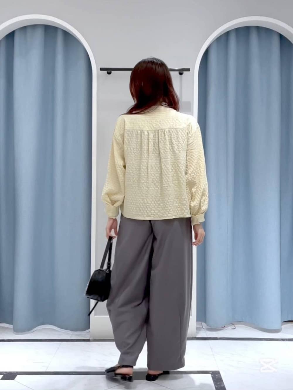 ブラック系のトートバッグ、ブラック系のパンプス、イエロー系のTシャツ/カットソーを着用したレディースの春コーディネートの2枚目の写真