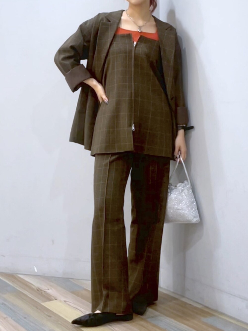 ブラウン系のスラックス、ブラック系のパンプス、シルバー系のショルダーバッグを着用したレディースの秋コーディネートの4枚目の写真