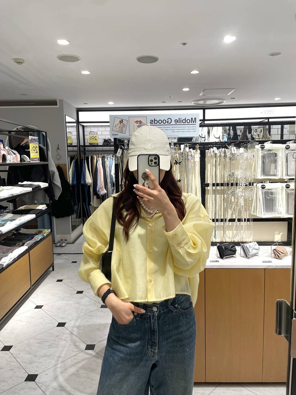 ブルー系のデニムパンツ、イエロー系のシャツ/ブラウス、シルバー系のスニーカーを着用したレディースの春コーディネートの3枚目の写真