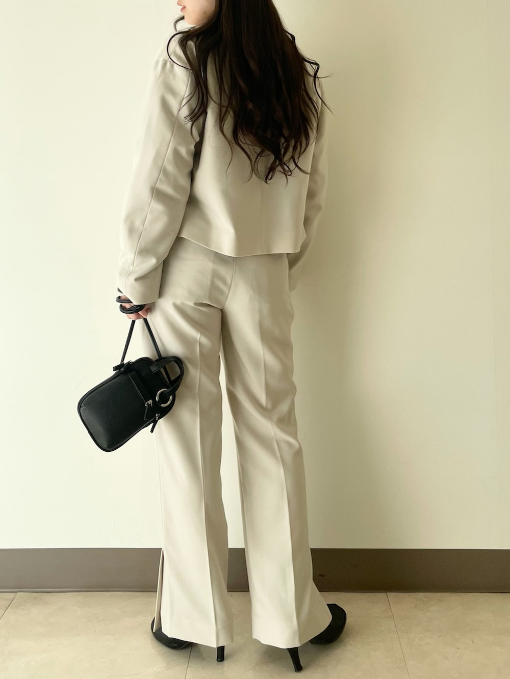 ホワイト系のテーラードジャケット、ホワイト系のその他パンツ、ブラック系のショルダーバッグを着用したレディースの冬コーディネートの2枚目の写真