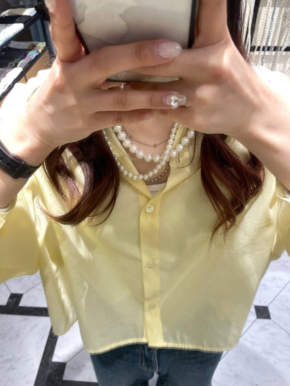 ブルー系のデニムパンツ、イエロー系のシャツ/ブラウス、シルバー系のスニーカーを着用したレディースの春コーディネートの2枚目の写真