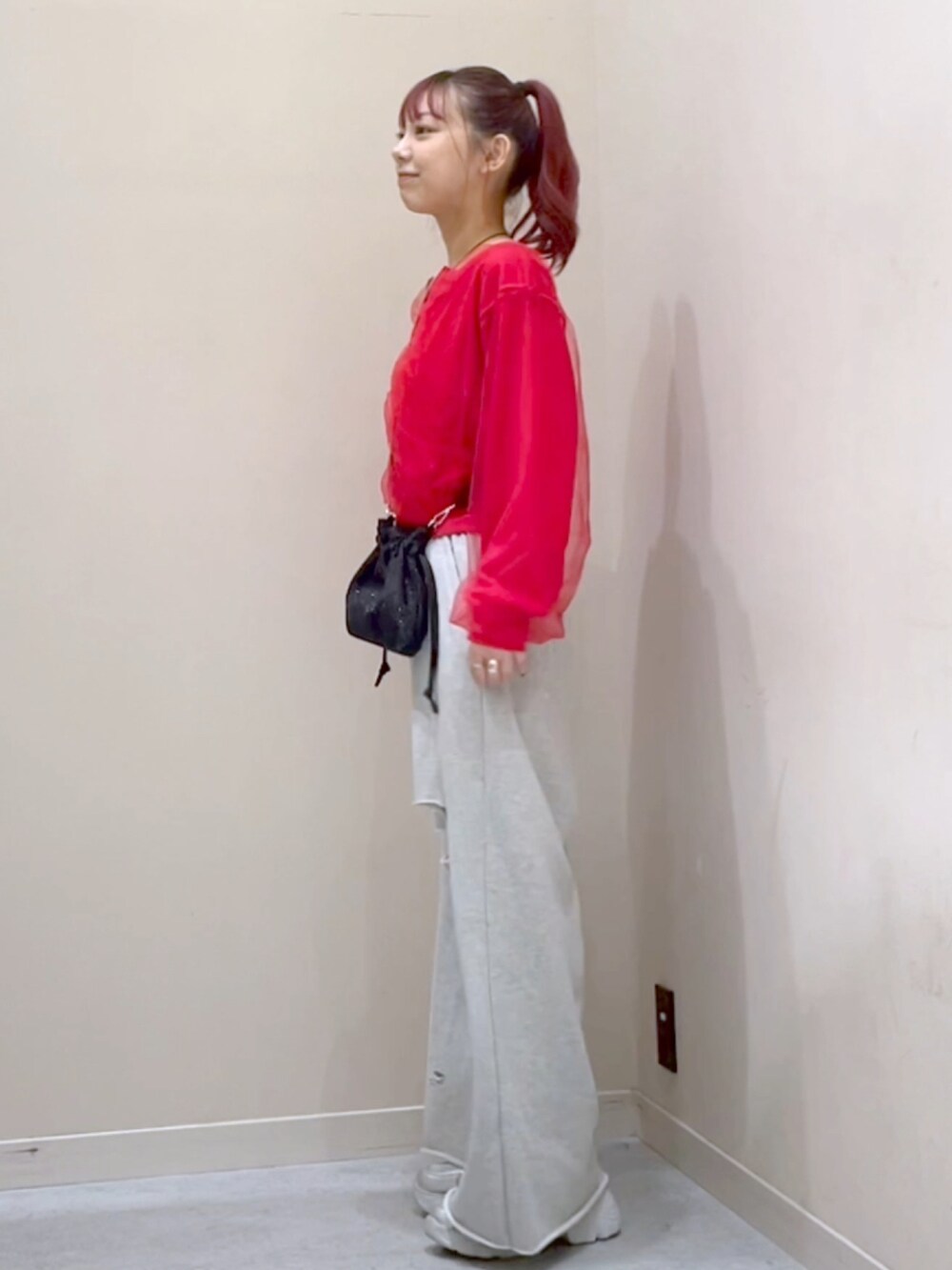 レッド系のカーディガン/ボレロ、グレー系のスウェットパンツを着用したレディースの秋コーディネートの3枚目の写真