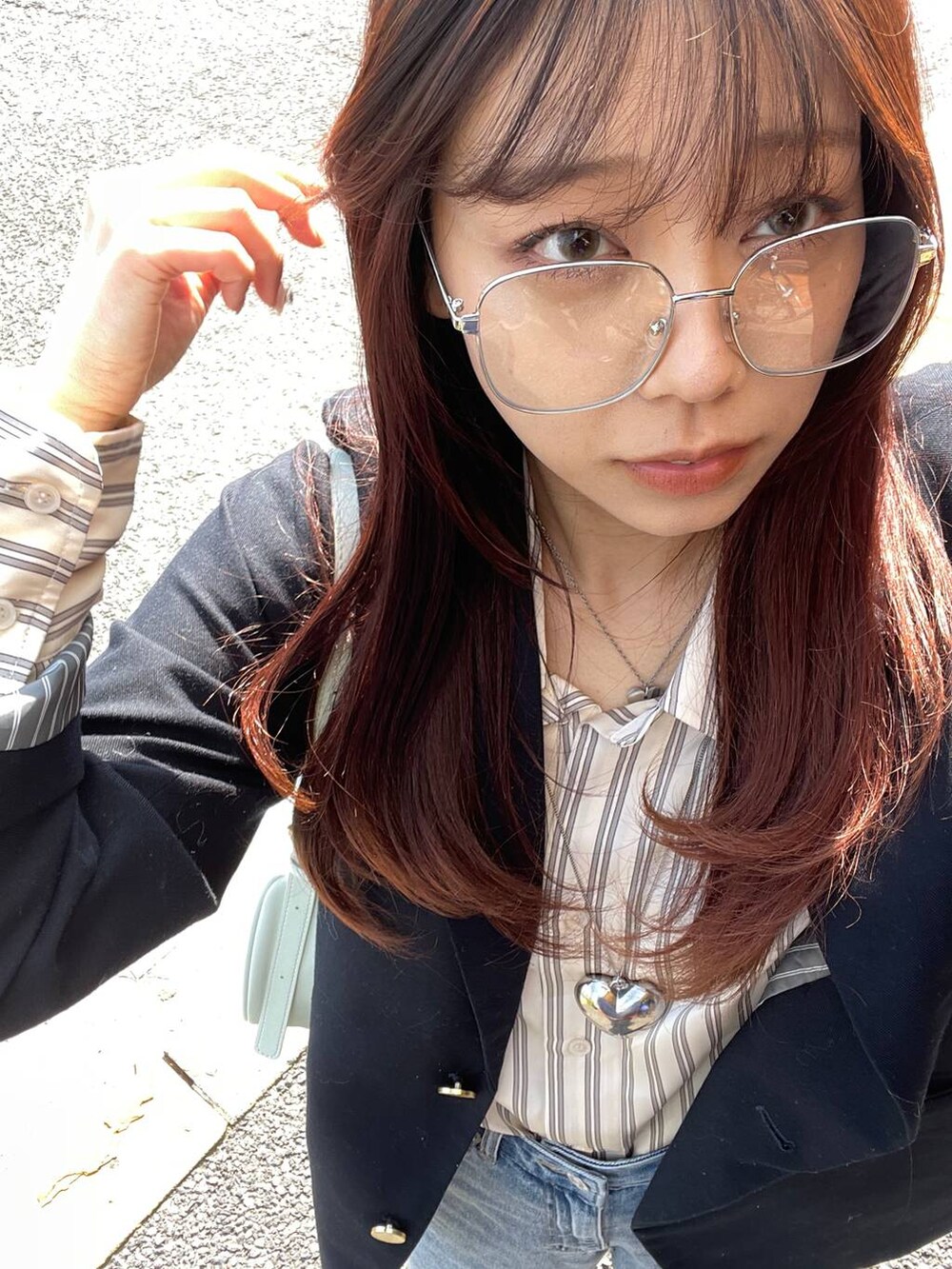 グリーン系のトートバッグ、ブルー系のデニムパンツを着用したレディースの春コーディネートの3枚目の写真