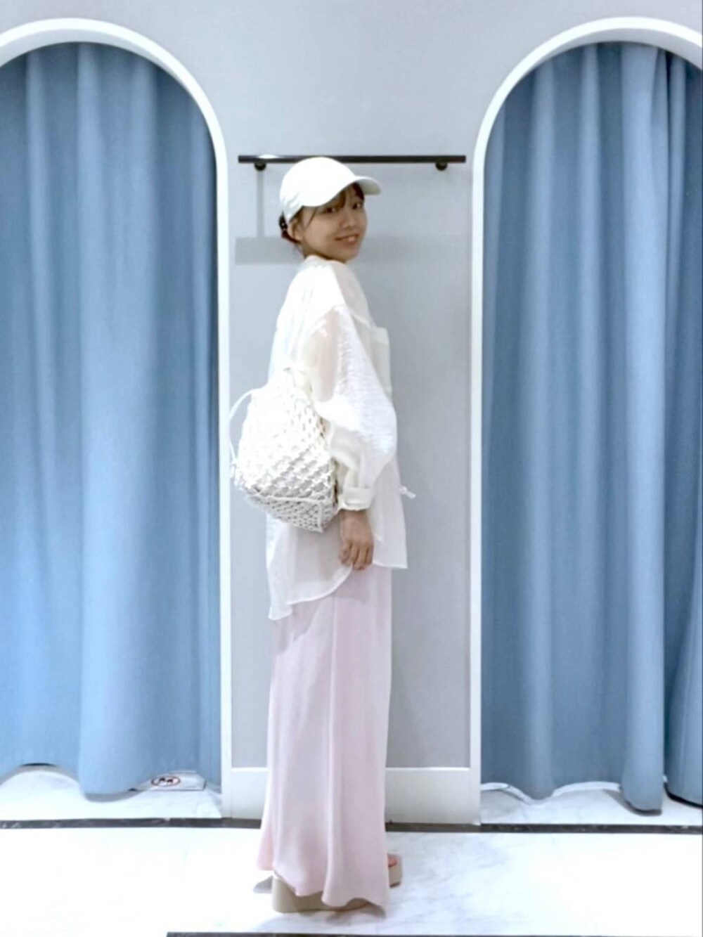 ホワイト系のサンダル、ホワイト系のトートバッグ、ピンク系のスカートを着用したレディースの春コーディネートの2枚目の写真