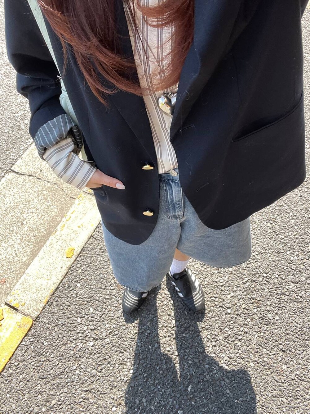 グリーン系のトートバッグ、ブルー系のデニムパンツを着用したレディースの春コーディネートの2枚目の写真