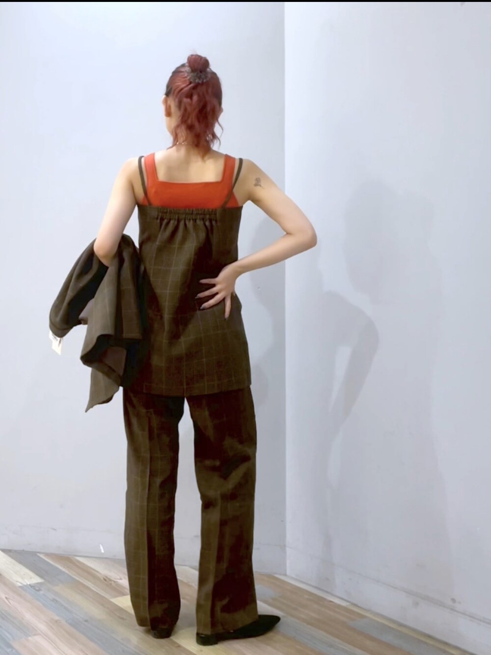 ブラウン系のスラックス、ブラック系のパンプス、シルバー系のショルダーバッグを着用したレディースの秋コーディネートの3枚目の写真