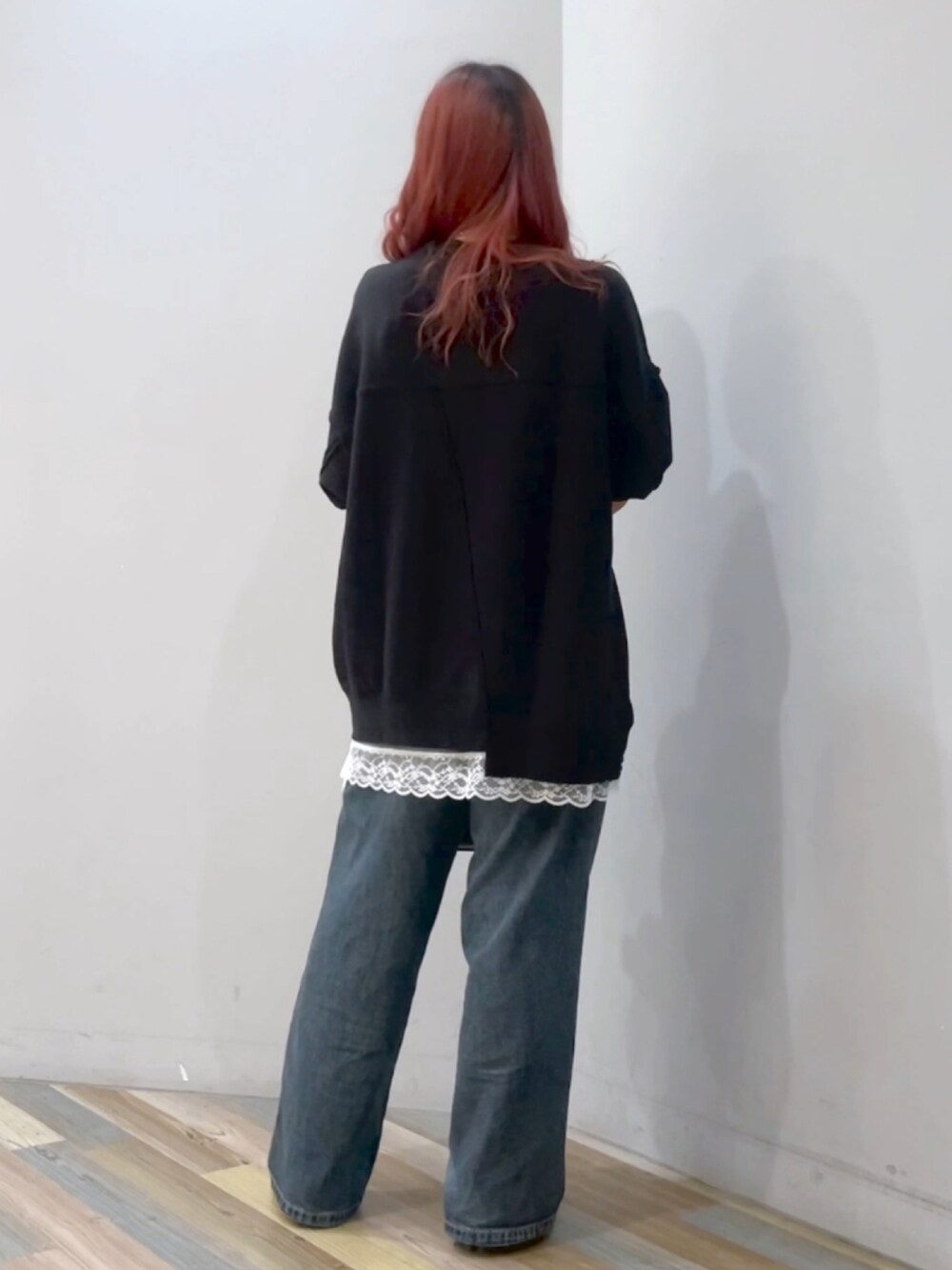 ブラック系のボストンバッグ、ブルー系のデニムパンツ、ブラック系のブーツを着用したレディースの秋コーディネートの3枚目の写真