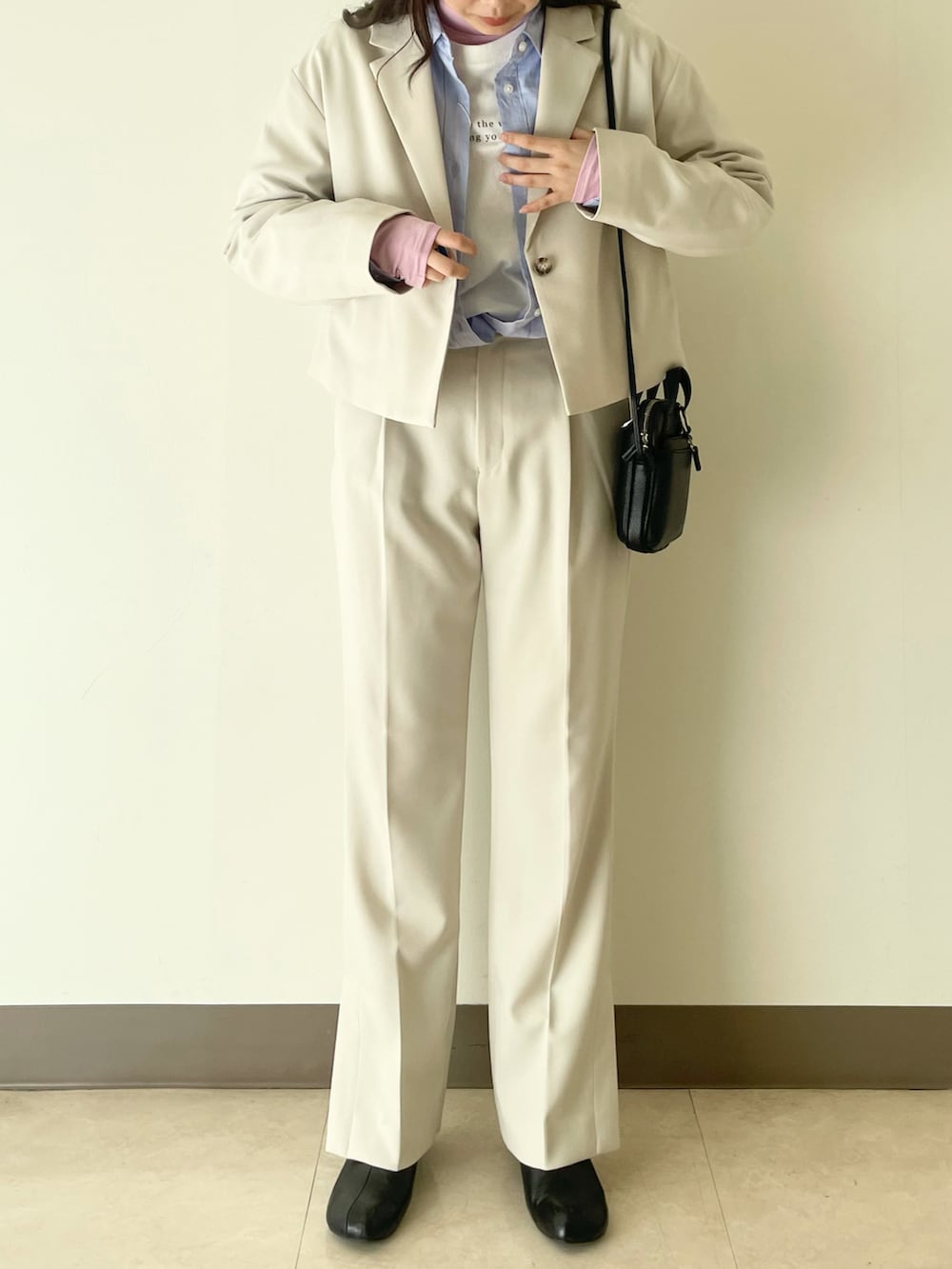 ホワイト系のテーラードジャケット、ホワイト系のその他パンツ、ブラック系のショルダーバッグを着用したレディースの冬コーディネートの3枚目の写真