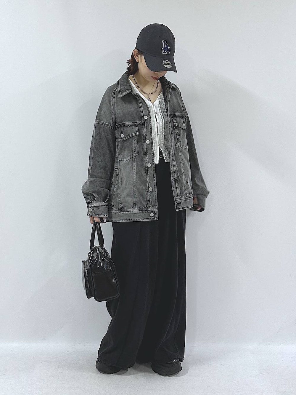 ブラック系のスニーカー、ブラック系のスウェットパンツ、ブラック系のブルゾンを着用したレディースの春コーディネートの2枚目の写真