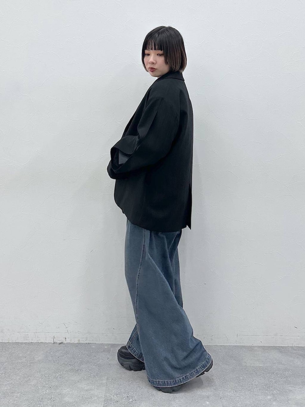 ブルー系のデニムパンツ、ブラック系のテーラードジャケット、ベージュ系のTシャツ/カットソーを着用したレディースの春コーディネートの4枚目の写真