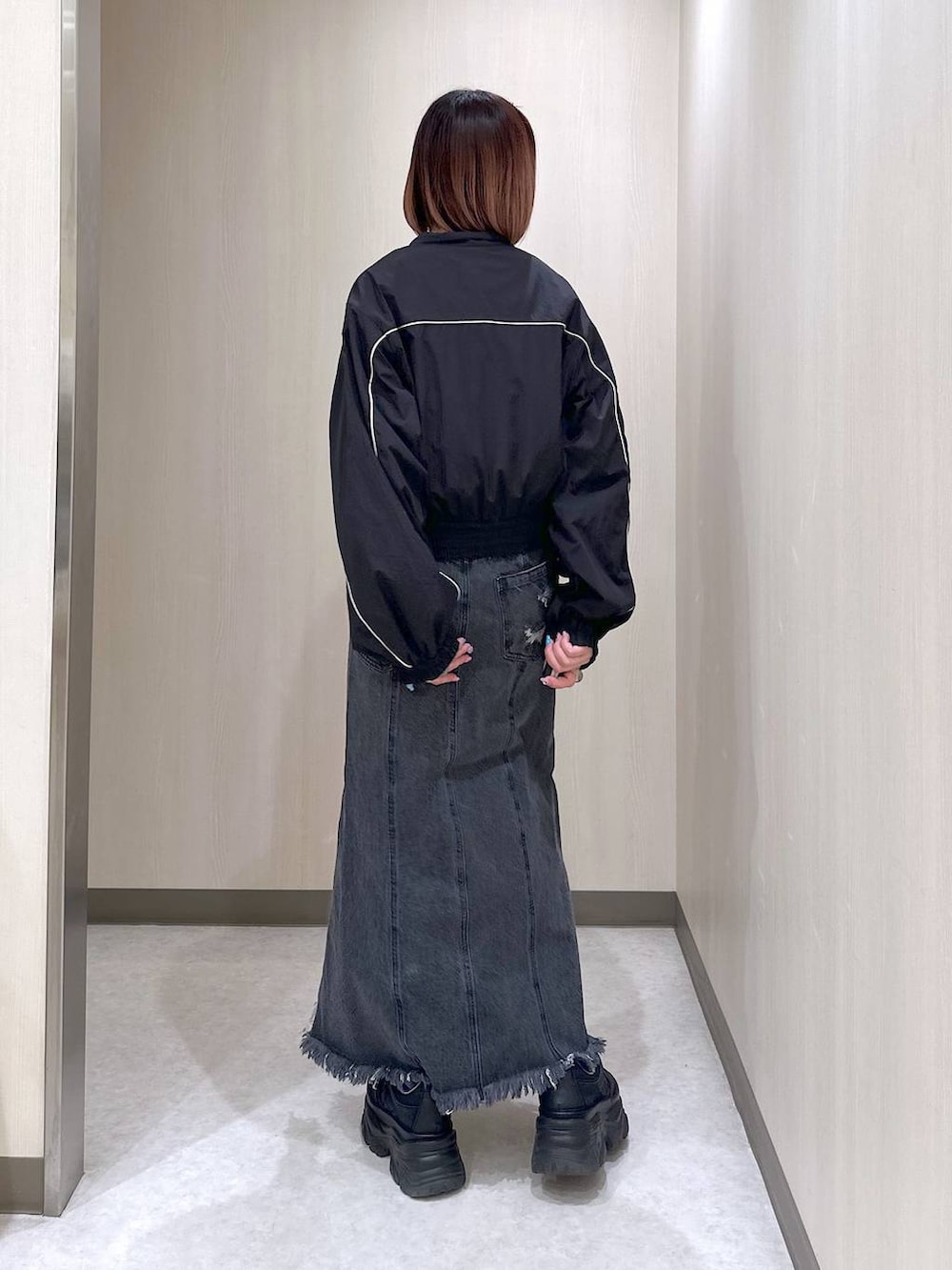 ブラック系のブルゾン、ブルー系のタンクトップ、ブラック系のスニーカーを着用したレディースの春コーディネートの4枚目の写真