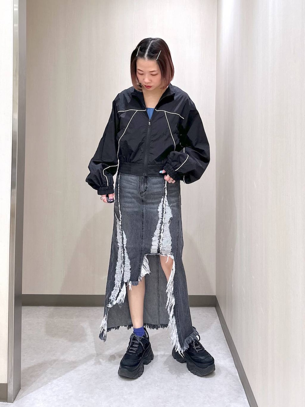 ブラック系のブルゾン、ブルー系のタンクトップ、ブラック系のスニーカーを着用したレディースの春コーディネートの3枚目の写真