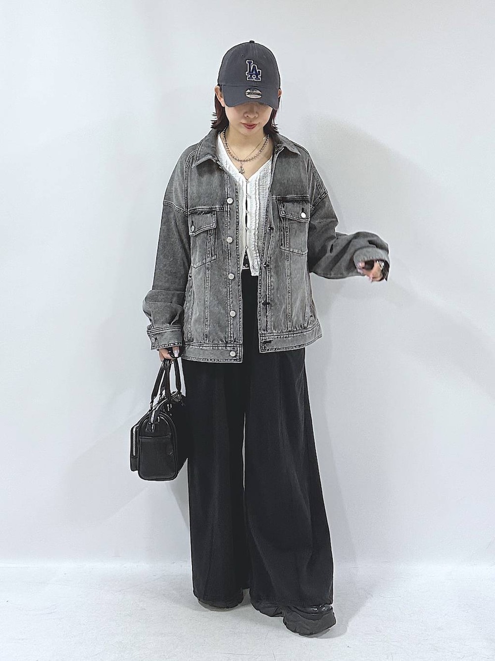 ブラック系のスニーカー、ブラック系のスウェットパンツ、ブラック系のブルゾンを着用したレディースの春コーディネートの4枚目の写真