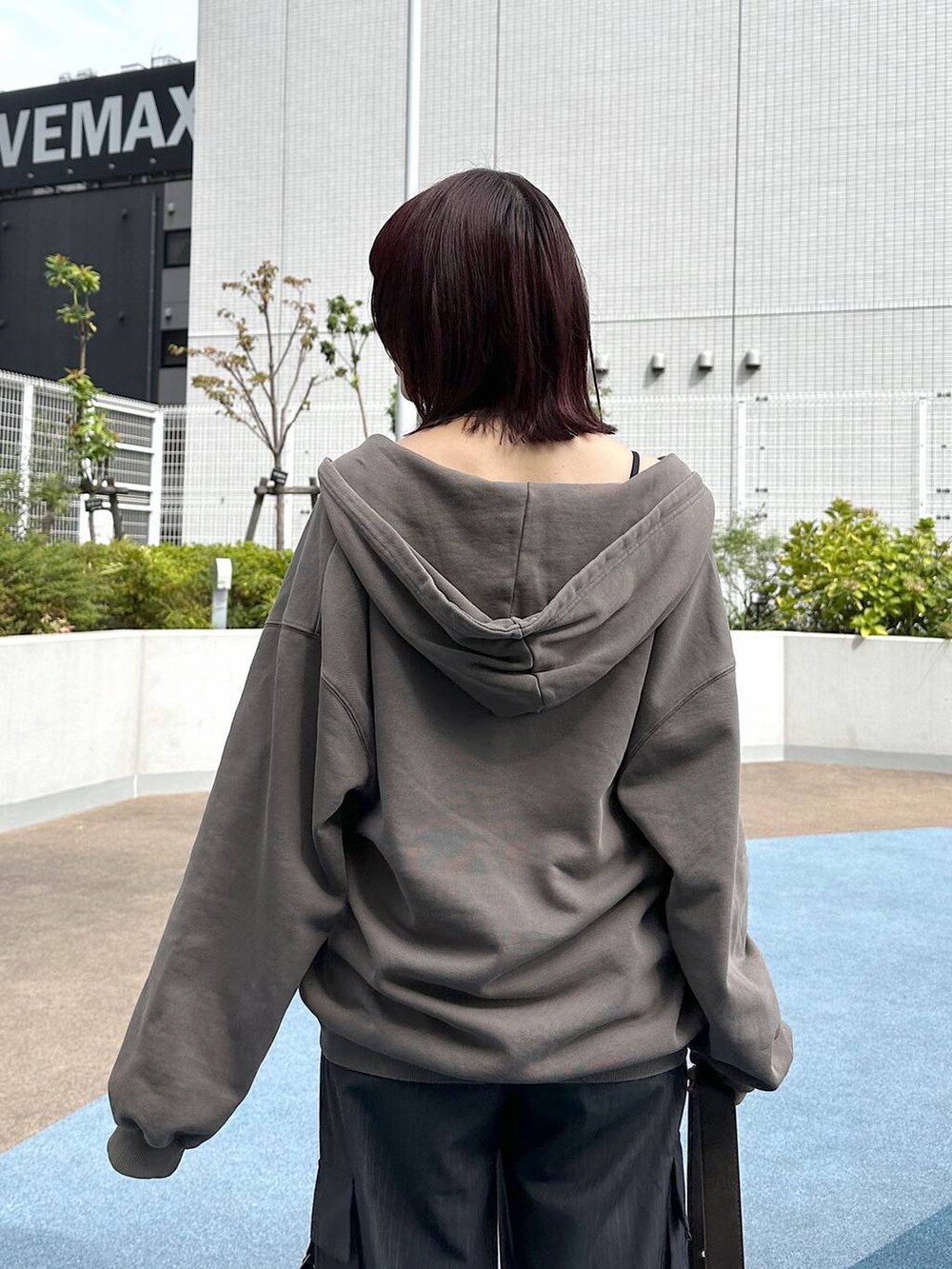 ブラック系のスニーカー、グレー系のスラックス、ブラウン系のパーカーを着用したレディースの秋コーディネートの8枚目の写真