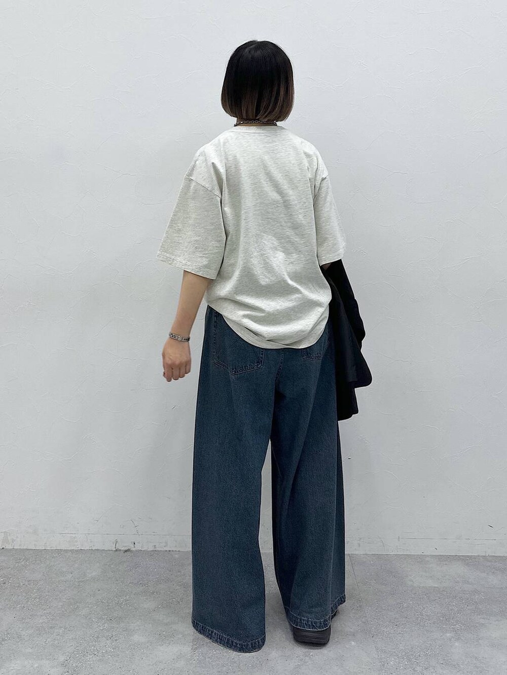 ブルー系のデニムパンツ、ブラック系のテーラードジャケット、ベージュ系のTシャツ/カットソーを着用したレディースの春コーディネートの10枚目の写真