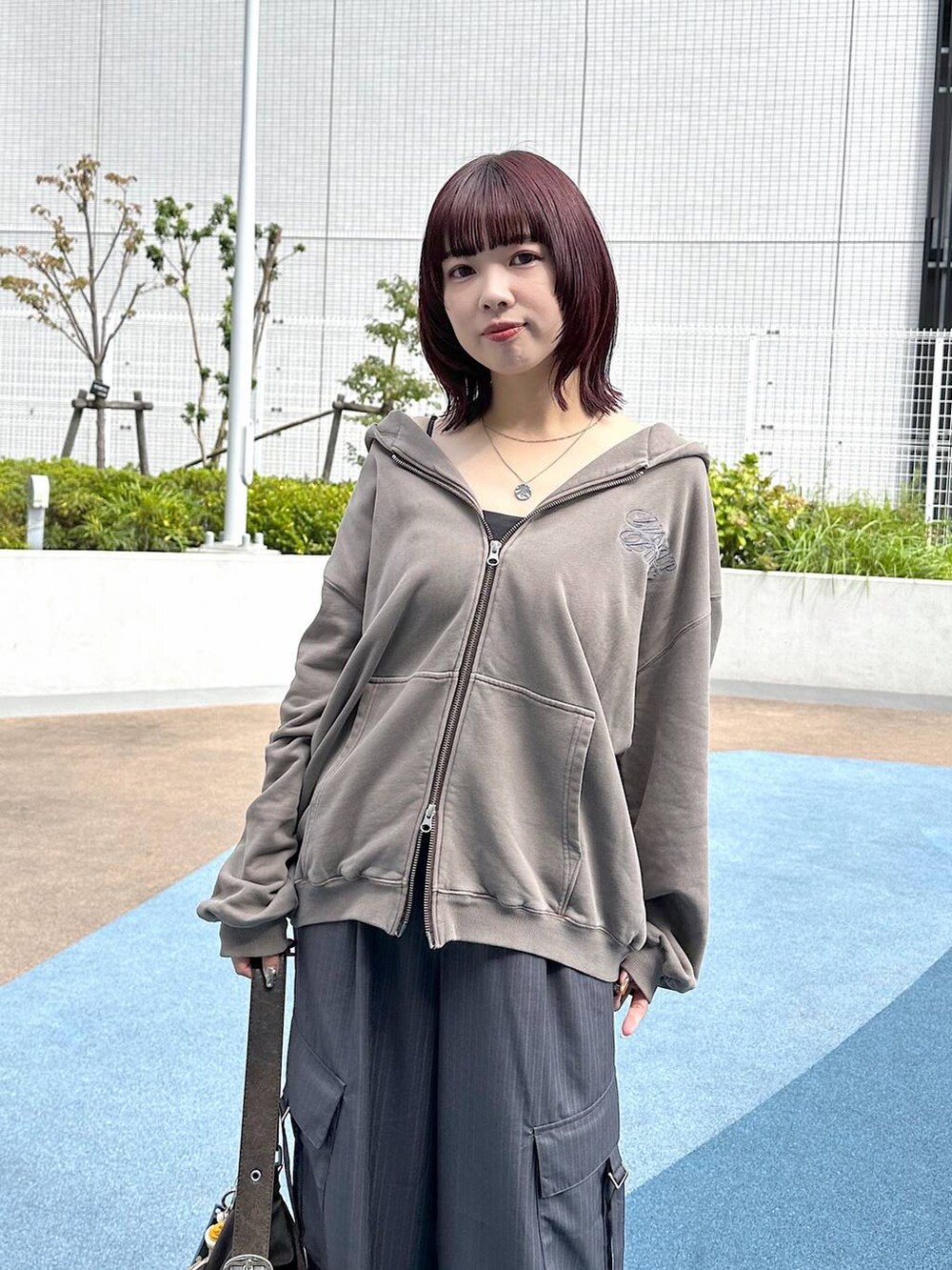 ブラック系のスニーカー、グレー系のスラックス、ブラウン系のパーカーを着用したレディースの秋コーディネートの6枚目の写真