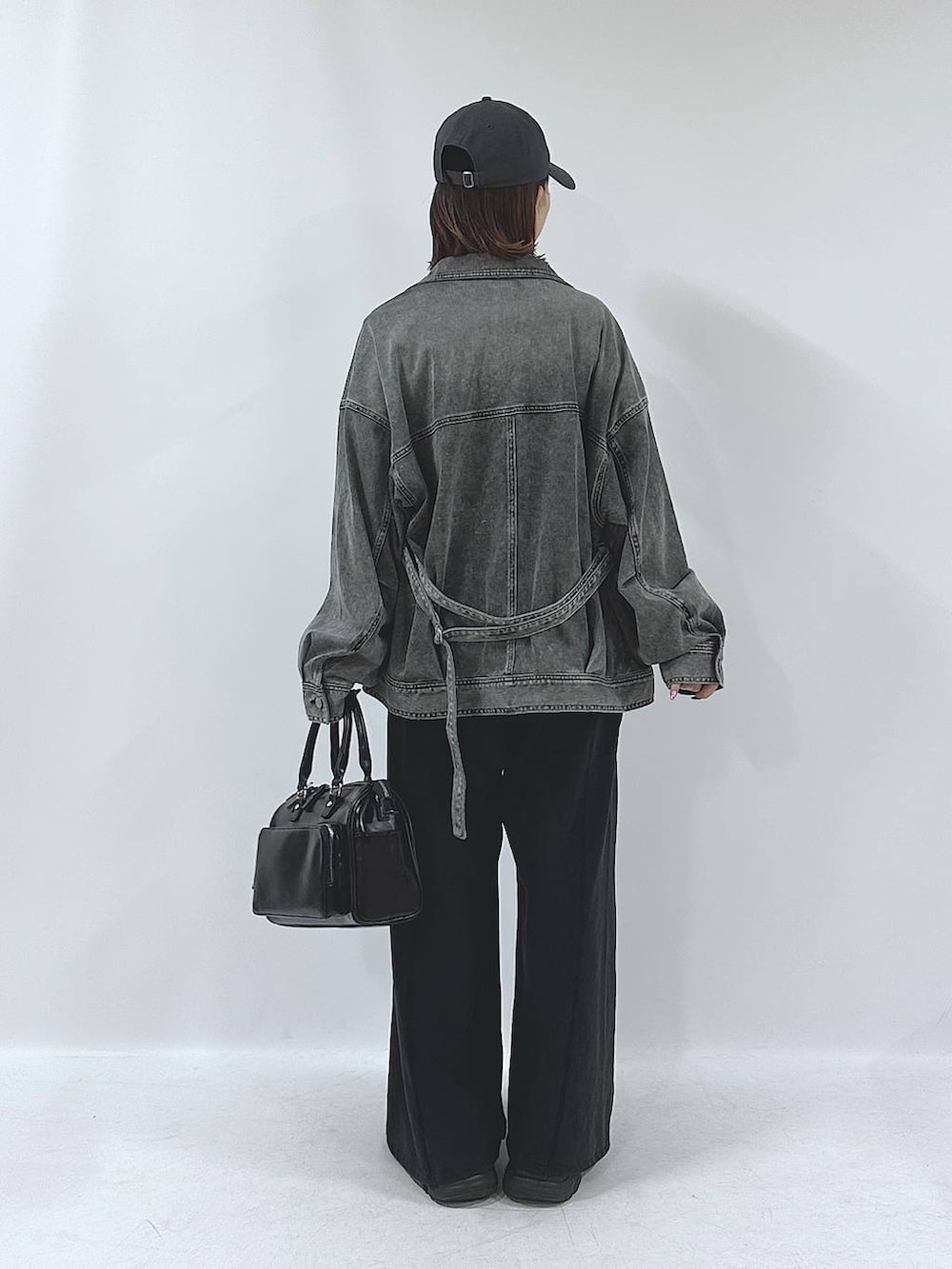 ブラック系のスニーカー、ブラック系のスウェットパンツ、ブラック系のブルゾンを着用したレディースの春コーディネートの7枚目の写真