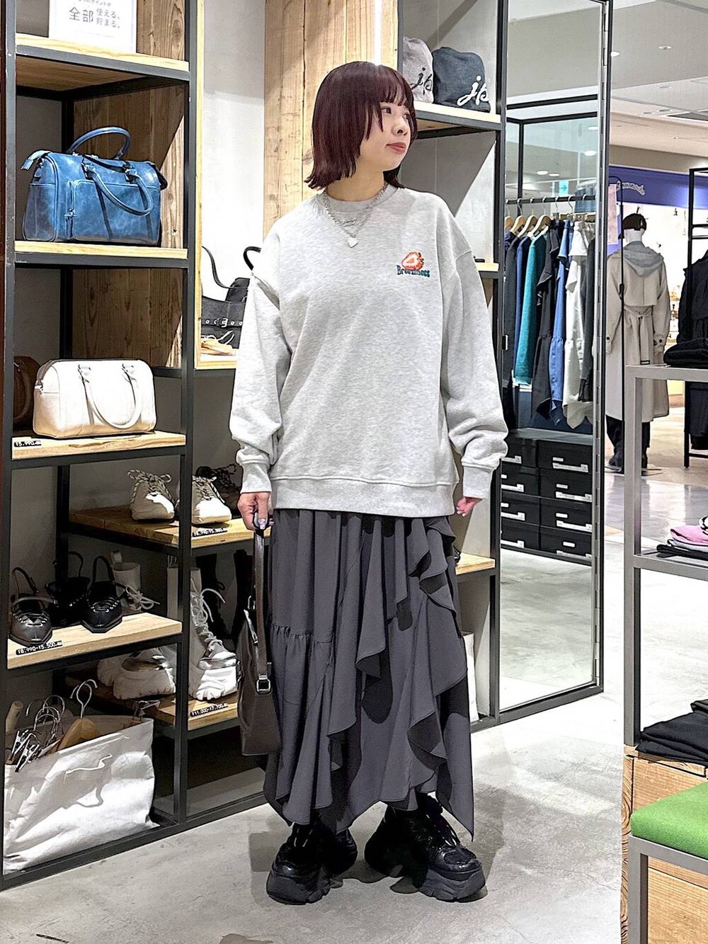 ブラック系のスニーカー、グレー系のスカート、グレー系のスウェットを着用したレディースの春コーディネートの5枚目の写真