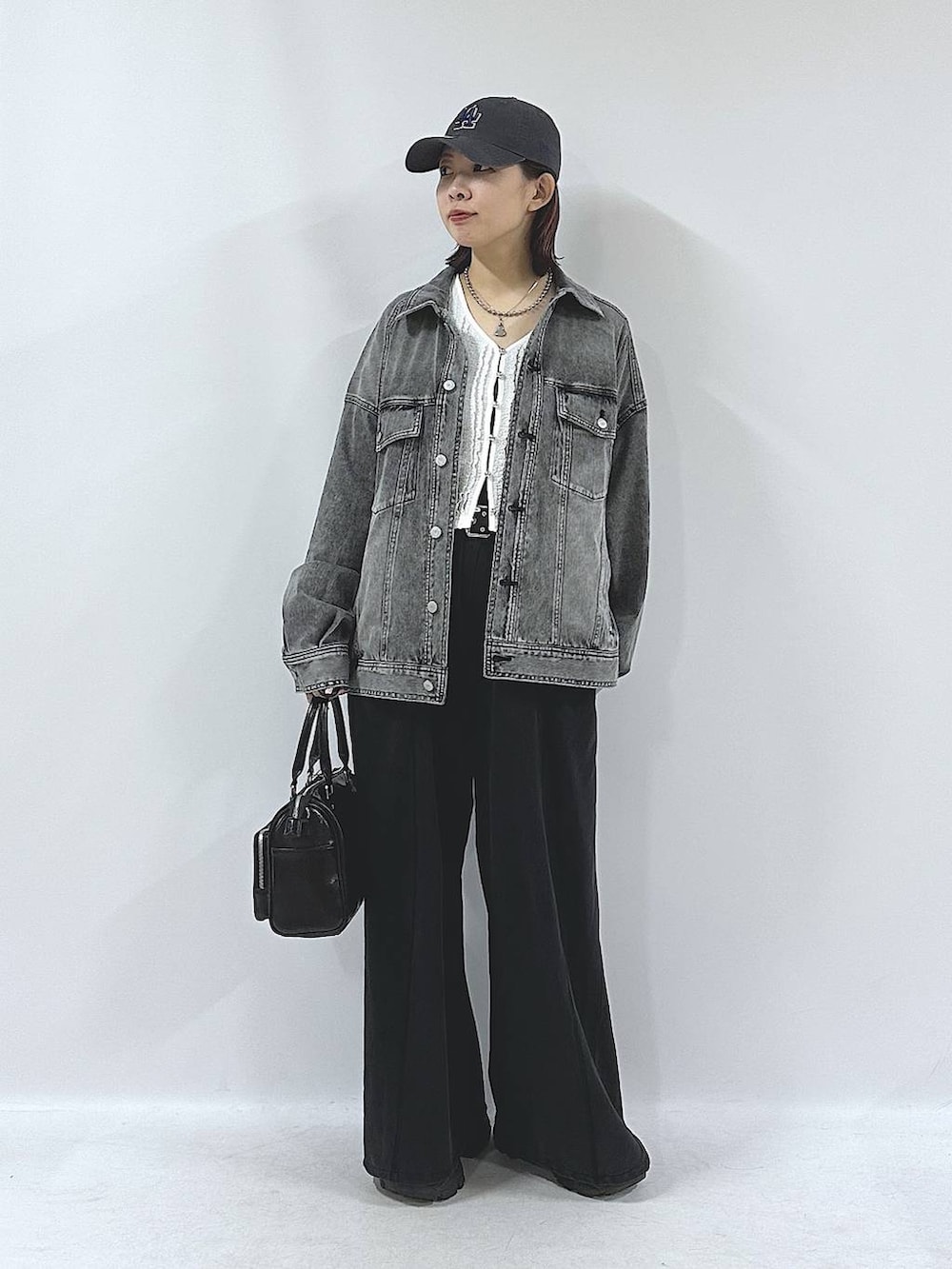 ブラック系のスニーカー、ブラック系のスウェットパンツ、ブラック系のブルゾンを着用したレディースの春コーディネートの3枚目の写真