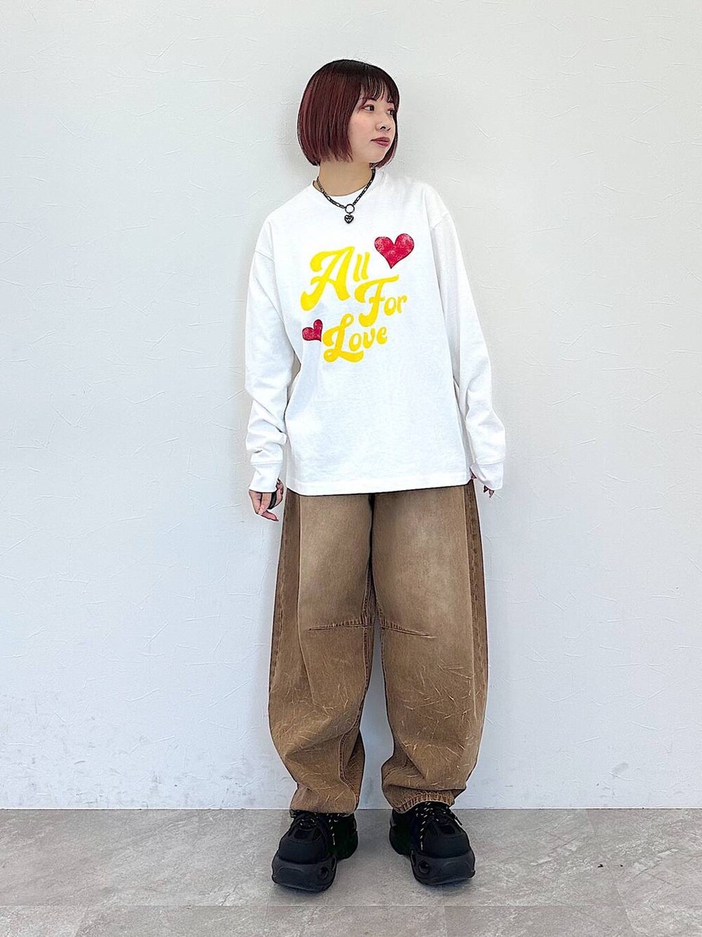 ブラック系のハンドバッグ、ベージュ系のデニムパンツ、ベージュ系のカーディガン/ボレロを着用したレディースの冬コーディネートの7枚目の写真