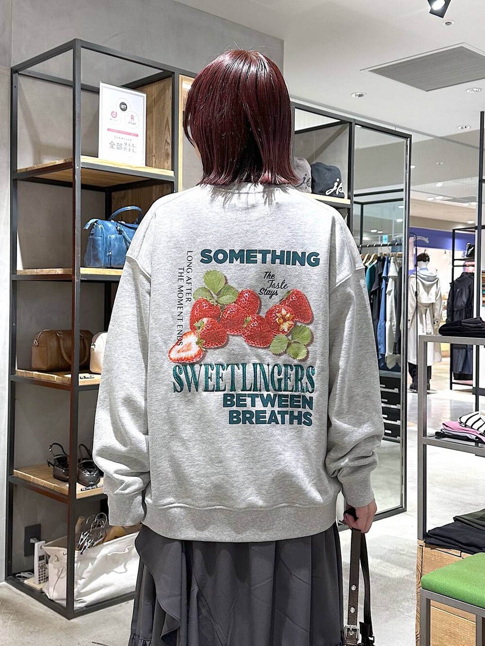 ブラック系のスニーカー、グレー系のスカート、グレー系のスウェットを着用したレディースの春コーディネートの2枚目の写真