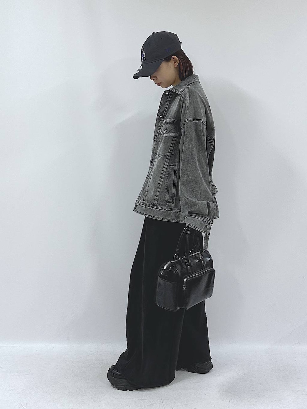 ブラック系のスニーカー、ブラック系のスウェットパンツ、ブラック系のブルゾンを着用したレディースの春コーディネートの6枚目の写真