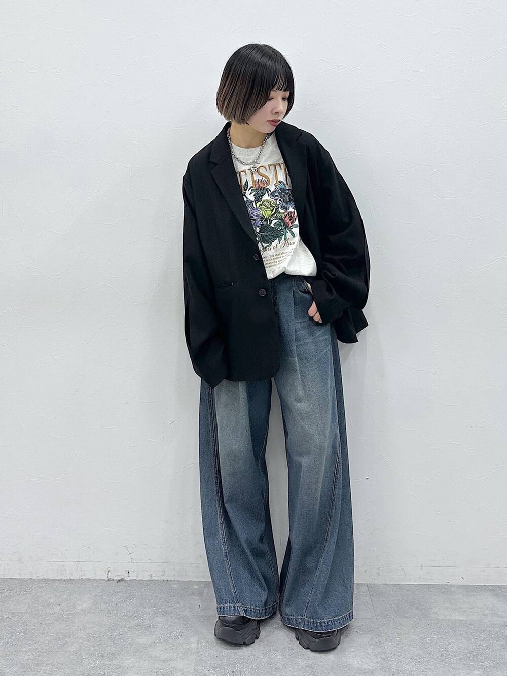 ブルー系のデニムパンツ、ブラック系のテーラードジャケット、ベージュ系のTシャツ/カットソーを着用したレディースの春コーディネートの2枚目の写真