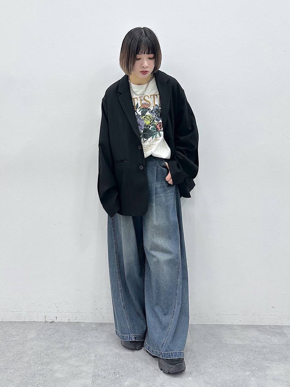 ブルー系のデニムパンツ、ブラック系のテーラードジャケット、ベージュ系のTシャツ/カットソーを着用したレディースの春コーディネートの3枚目の写真