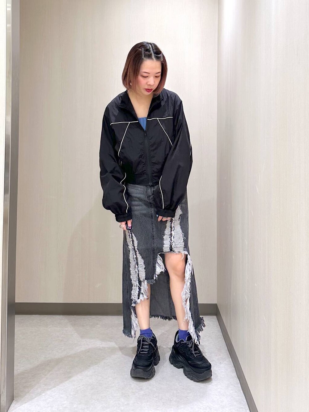 ブラック系のブルゾン、ブルー系のタンクトップ、ブラック系のスニーカーを着用したレディースの春コーディネートの2枚目の写真