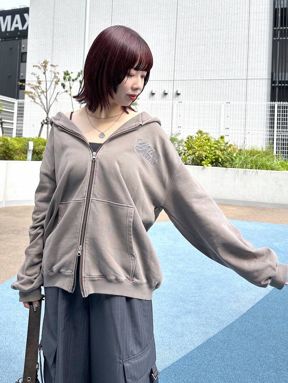 ブラック系のスニーカー、グレー系のスラックス、ブラウン系のパーカーを着用したレディースの秋コーディネートの7枚目の写真