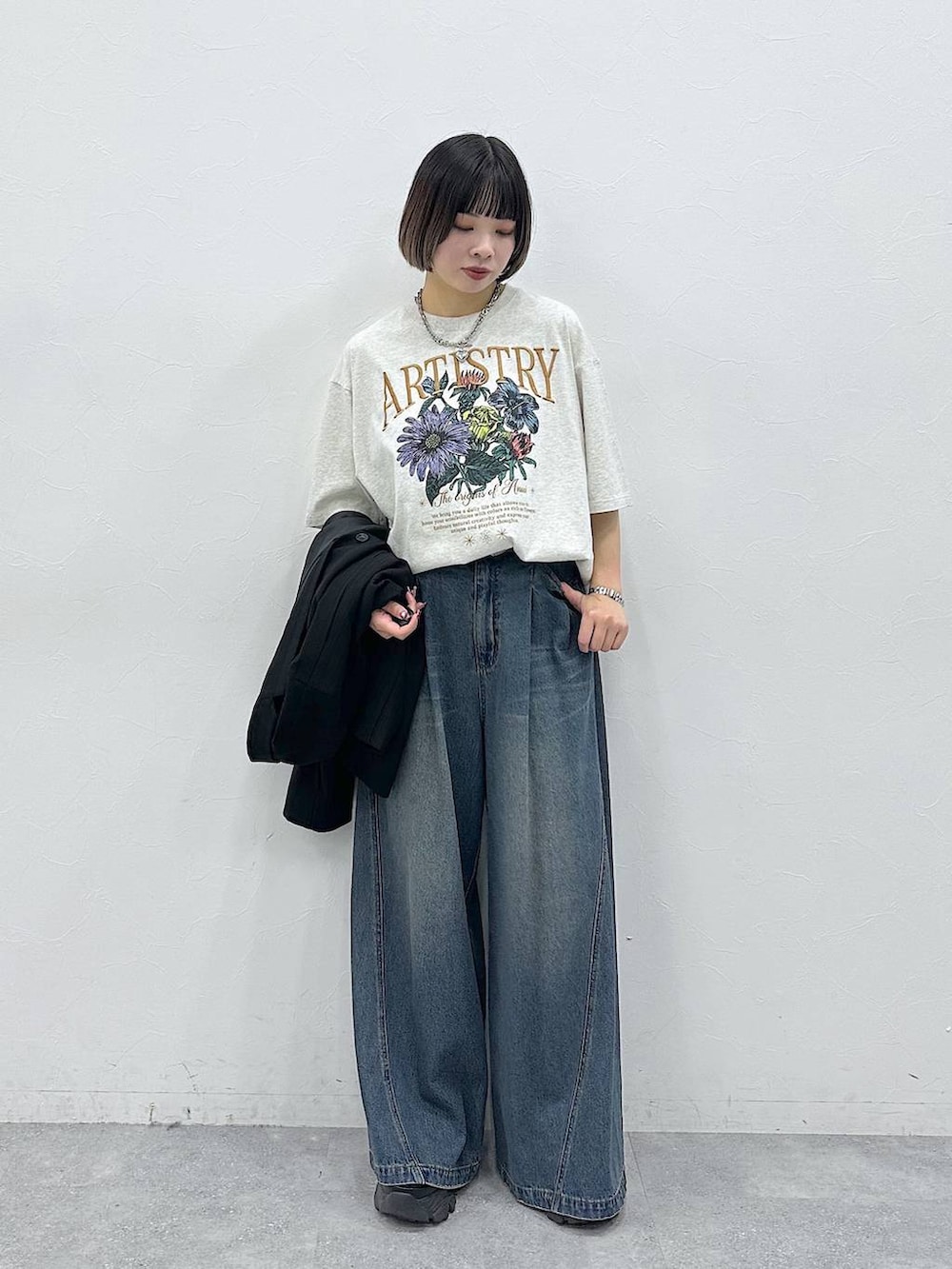 ブルー系のデニムパンツ、ブラック系のテーラードジャケット、ベージュ系のTシャツ/カットソーを着用したレディースの春コーディネートの6枚目の写真