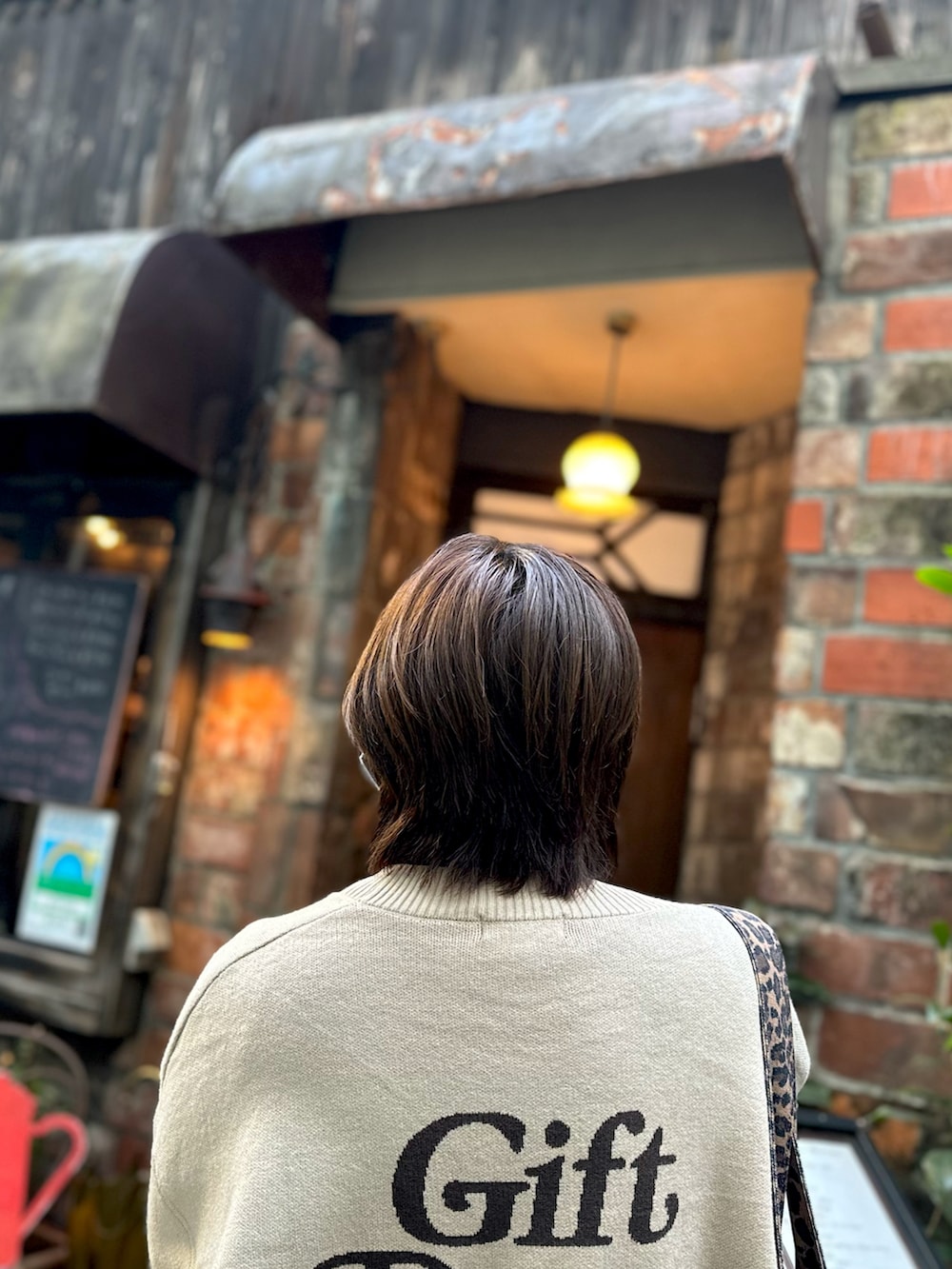 その他のスニーカー、ベージュ系のカーディガン/ボレロ、ブラック系のブルゾンを着用したレディースの冬コーディネートの2枚目の写真