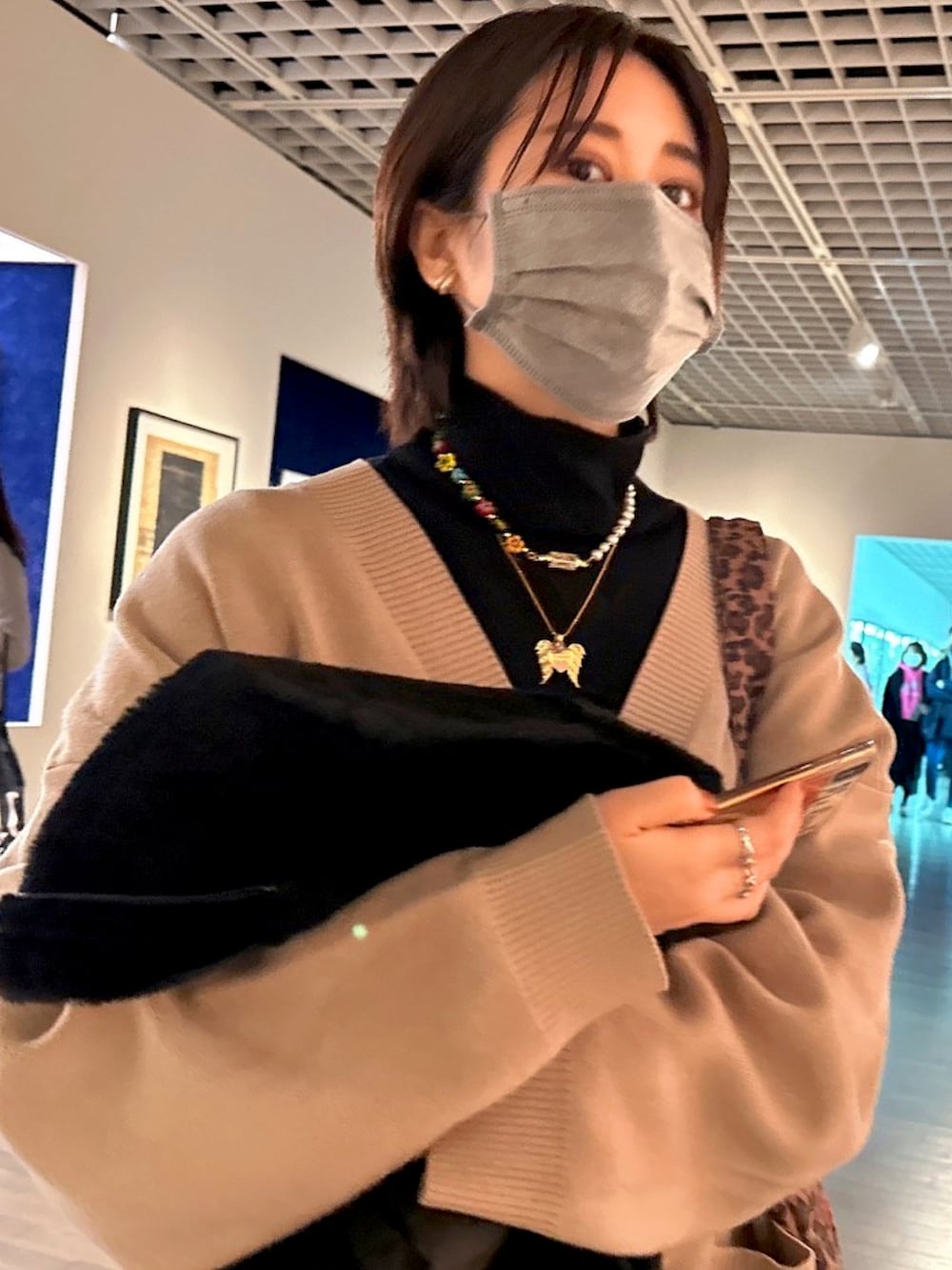 その他のスニーカー、ベージュ系のカーディガン/ボレロ、ブラック系のブルゾンを着用したレディースの冬コーディネートの3枚目の写真