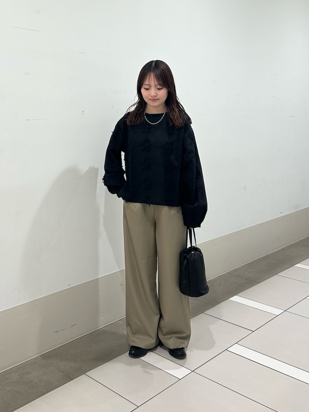 ベージュ系のその他パンツ、ブラック系のショルダーバッグ、ブラック系のシャツ/ブラウスを着用したレディースの春コーディネートの2枚目の写真