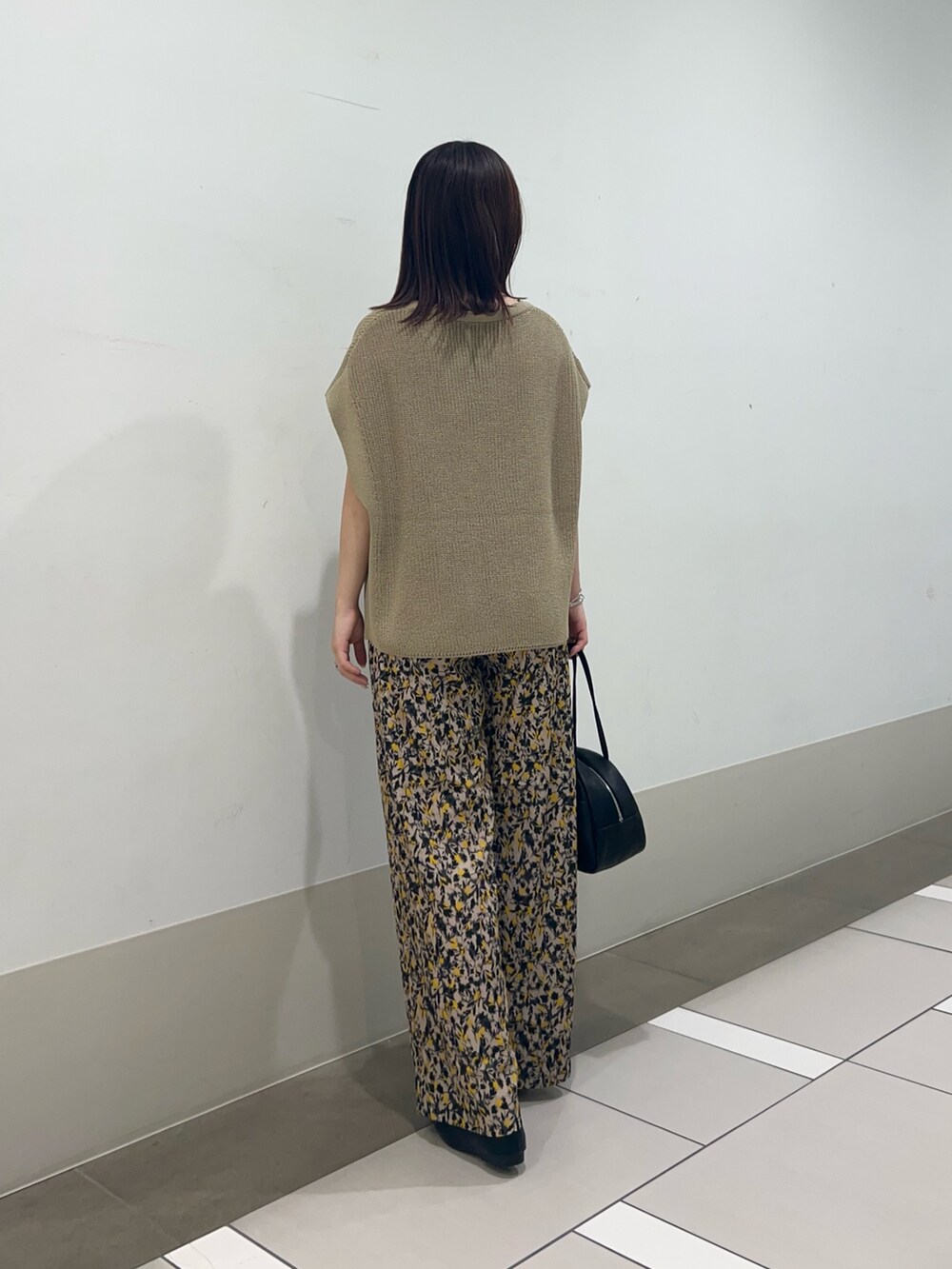 ベージュ系のニット/セーター、ベージュ系のその他パンツ、ブラック系のローファーを着用したレディースの夏コーディネートの4枚目の写真