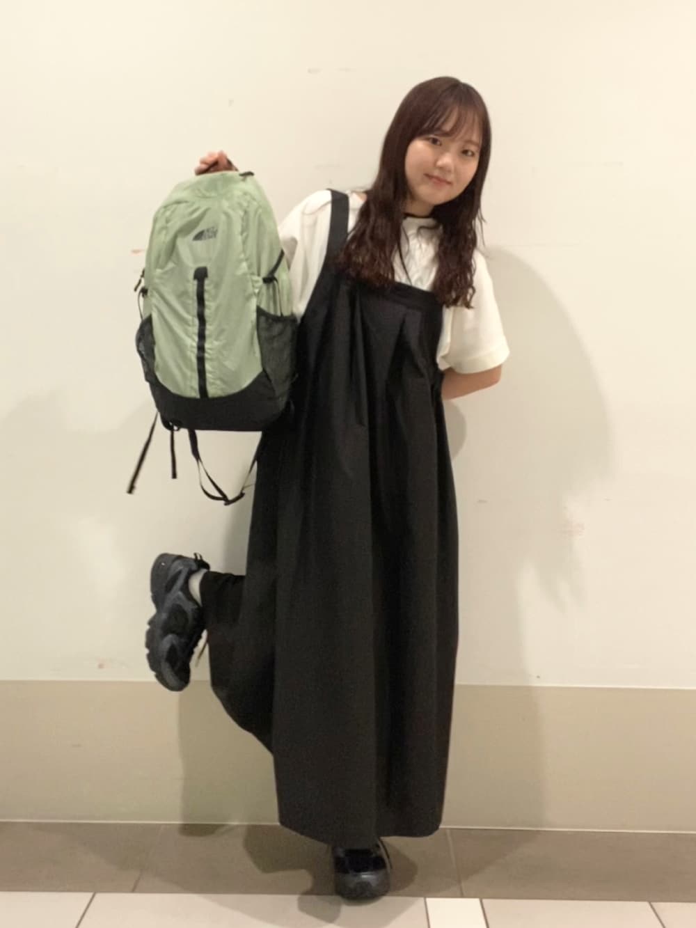 グリーン系のバックパック/リュック、ホワイト系のTシャツ/カットソー、ブラック系のワンピースを着用したレディースの夏コーディネートの4枚目の写真