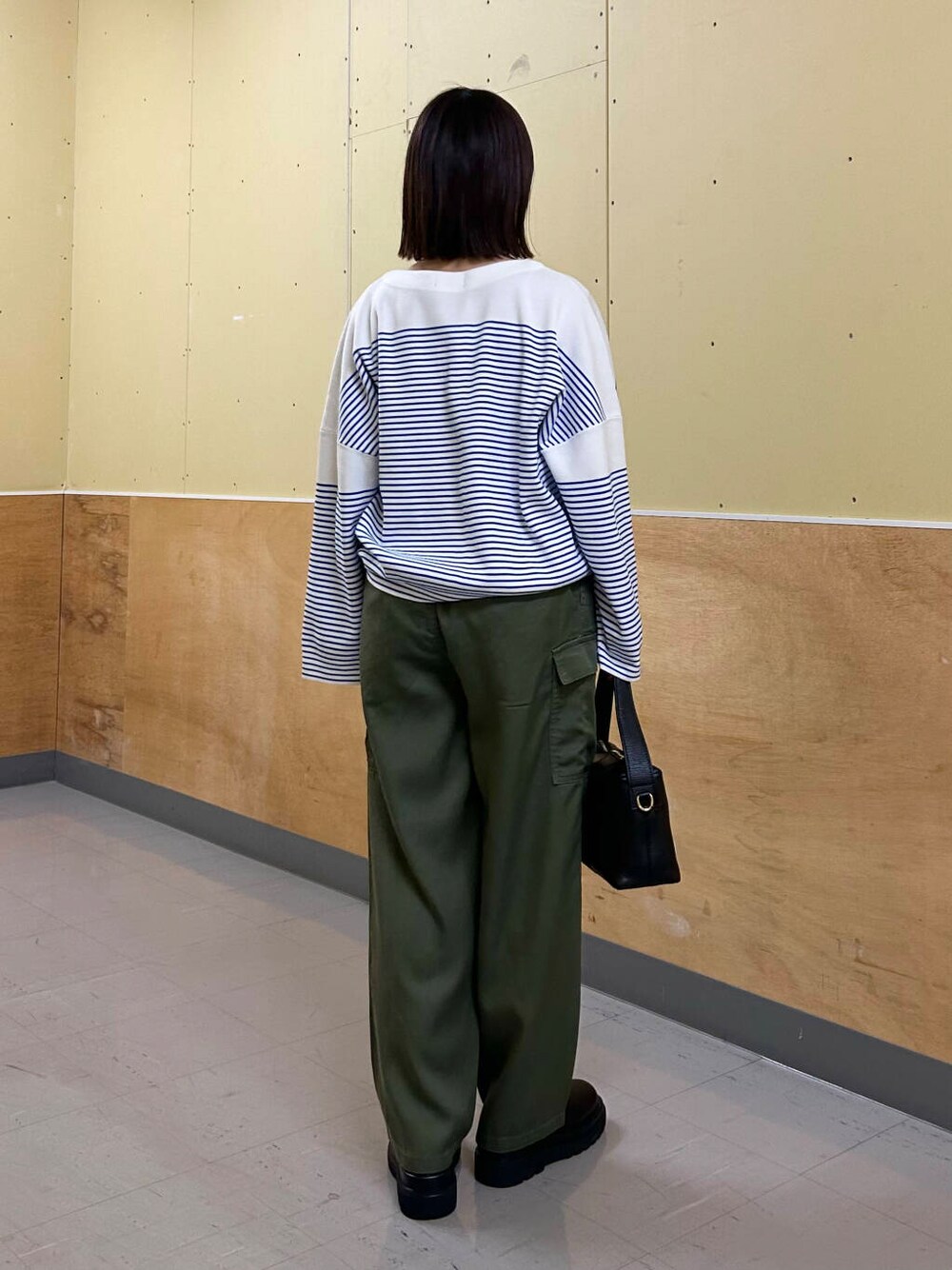 ブラック系のショルダーバッグ、グリーン系のその他パンツ、シルバー系のネックレスを着用したレディースの冬コーディネートの4枚目の写真