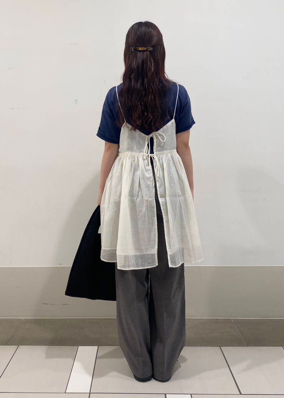 グレー系のその他パンツ、ブラック系のトートバッグ、ホワイト系のキャミソールを着用したレディースの夏コーディネートの5枚目の写真