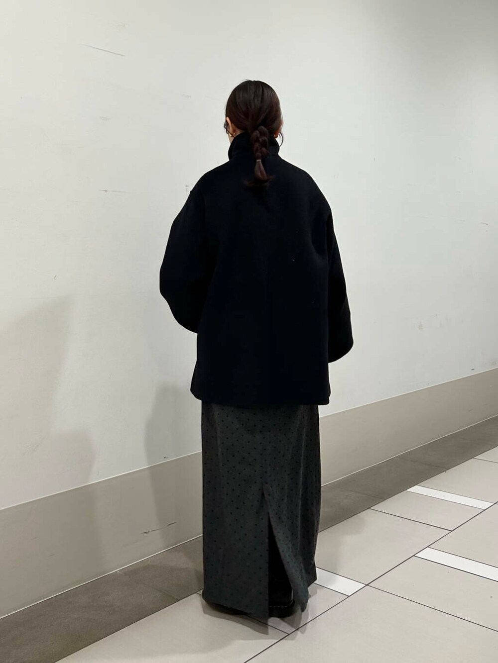 ホワイト系のシャツ/ブラウス、ブラック系のその他アウター、グレー系のスカートを着用したレディースの冬コーディネートの3枚目の写真