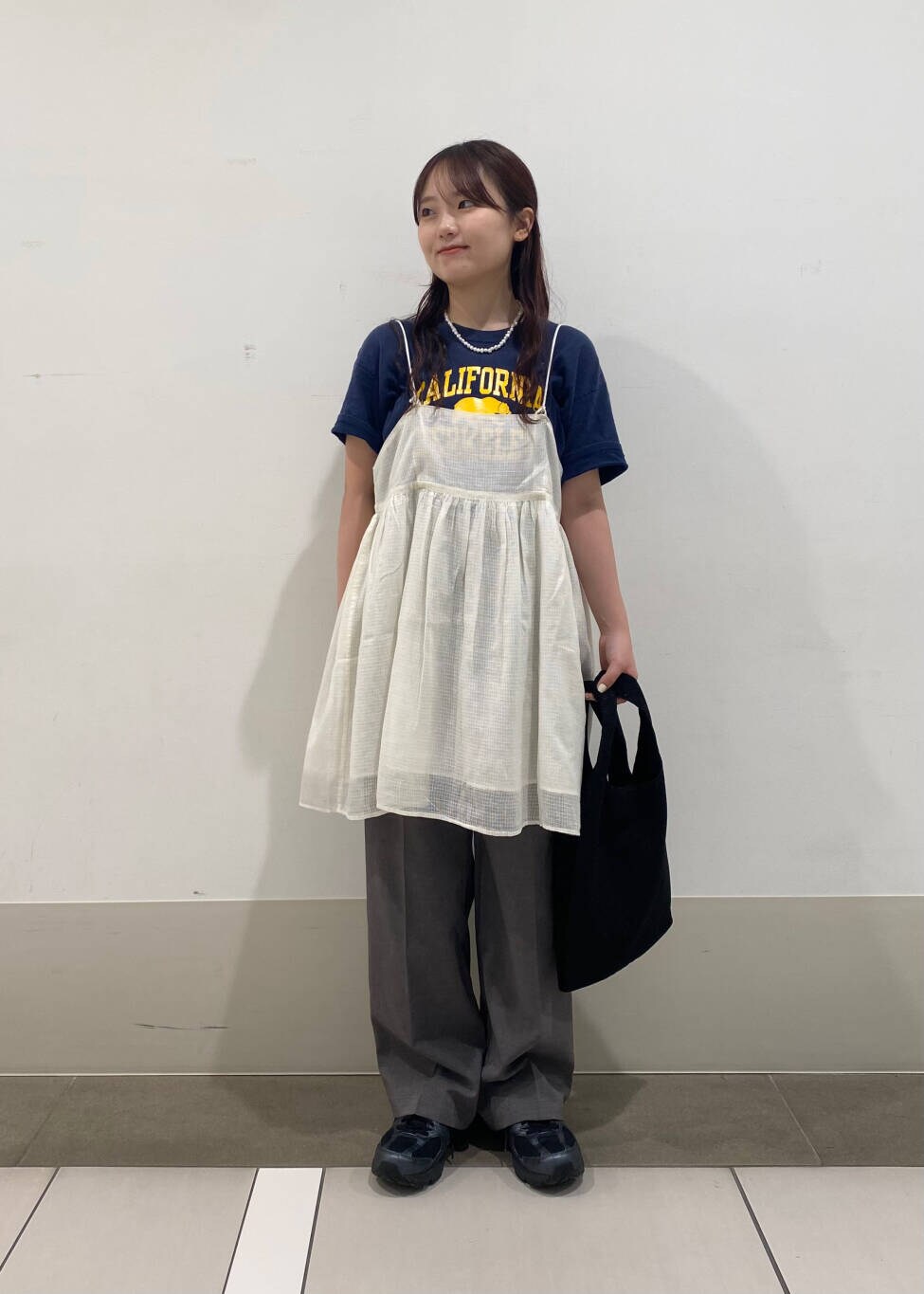 グレー系のその他パンツ、ブラック系のトートバッグ、ホワイト系のキャミソールを着用したレディースの夏コーディネートの2枚目の写真