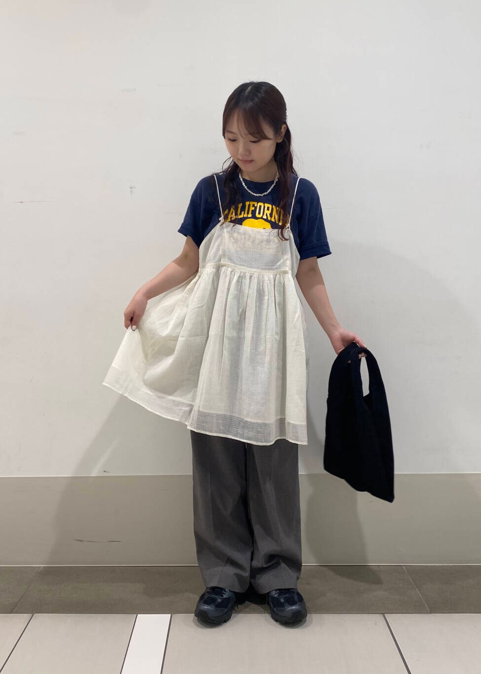 グレー系のその他パンツ、ブラック系のトートバッグ、ホワイト系のキャミソールを着用したレディースの夏コーディネートの3枚目の写真