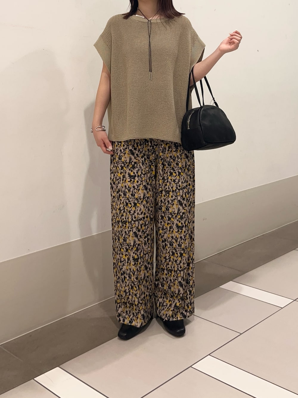 ベージュ系のニット/セーター、ベージュ系のその他パンツ、ブラック系のローファーを着用したレディースの夏コーディネートの3枚目の写真