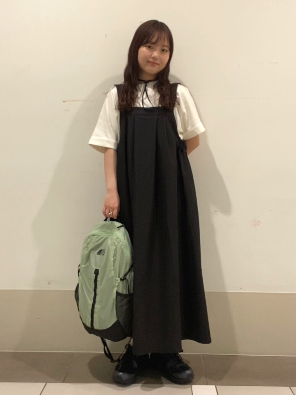グリーン系のバックパック/リュック、ホワイト系のTシャツ/カットソー、ブラック系のワンピースを着用したレディースの夏コーディネートの3枚目の写真