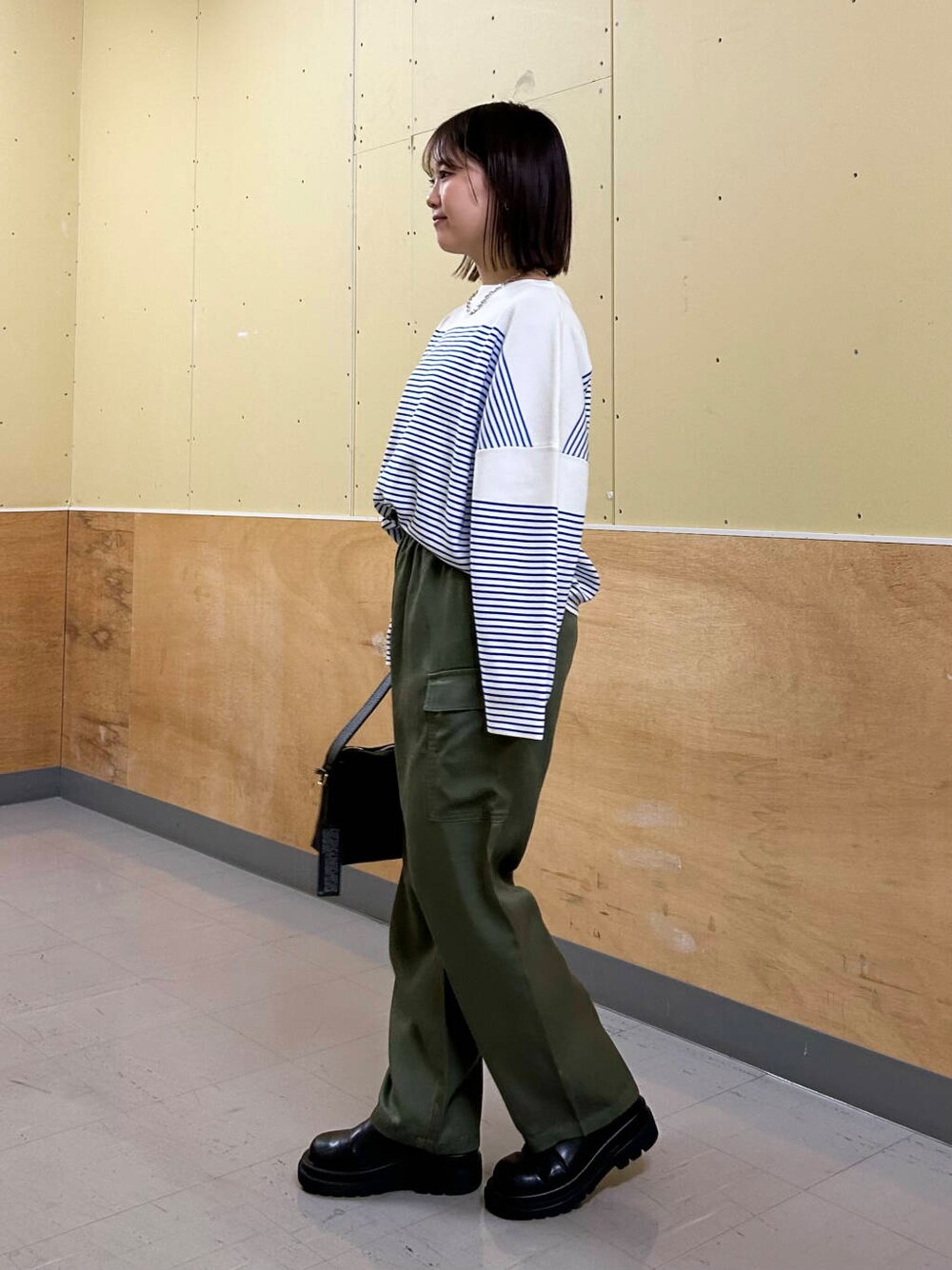 ブラック系のショルダーバッグ、グリーン系のその他パンツ、シルバー系のネックレスを着用したレディースの冬コーディネートの3枚目の写真