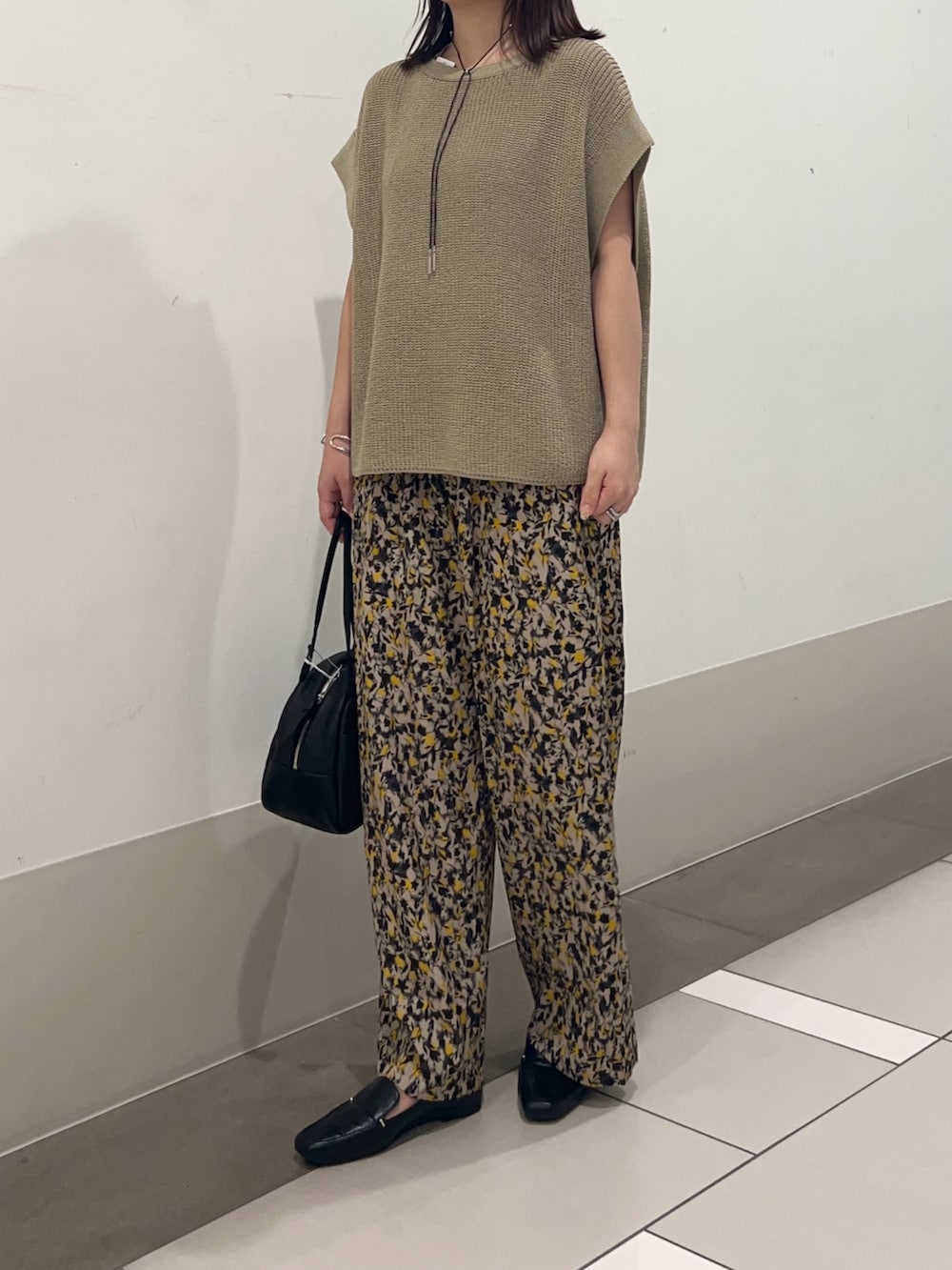 ベージュ系のニット/セーター、ベージュ系のその他パンツ、ブラック系のローファーを着用したレディースの夏コーディネートの2枚目の写真