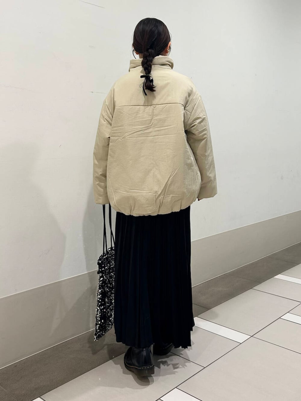 ベージュ系のブルゾン、シルバー系のトートバッグ、ブラック系のスカートを着用したレディースの冬コーディネートの4枚目の写真