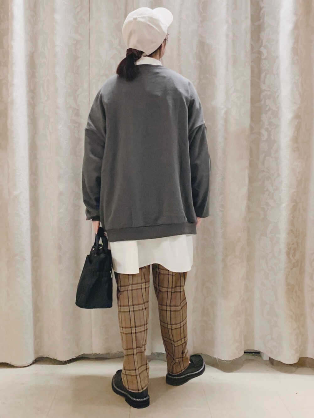 グレー系のスウェット、ホワイト系のシャツ/ブラウス、ブラウン系のパンツを着用したレディースの秋コーディネートの3枚目の写真