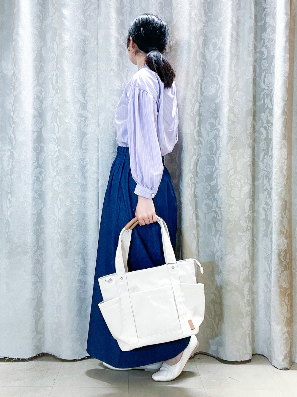 ピンク系のシャツ/ブラウス、ブルー系のデニムスカート、ホワイト系のパンプスを着用したレディースの春コーディネートの2枚目の写真