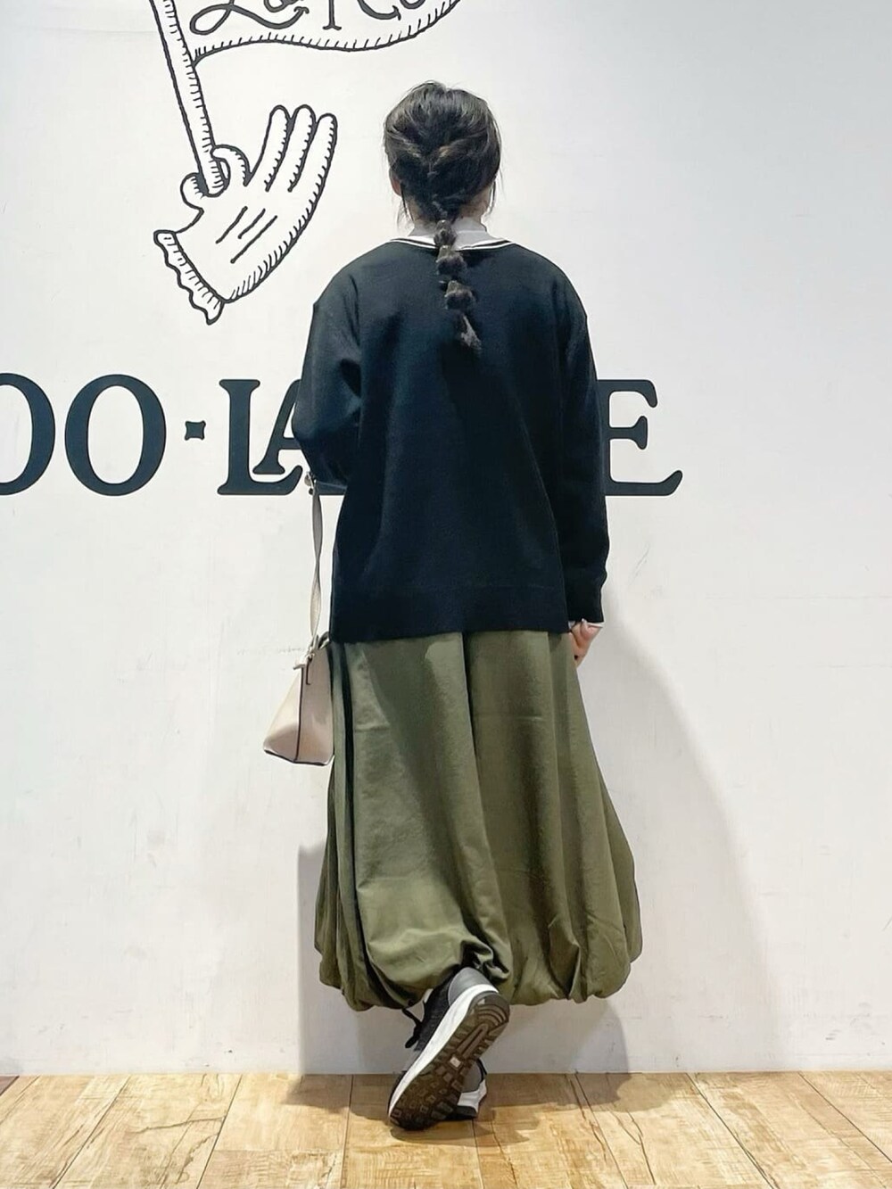 ブラック系のカーディガン/ボレロ、グリーン系のスカート、ホワイト系のTシャツ/カットソーを着用したレディースの冬コーディネートの3枚目の写真