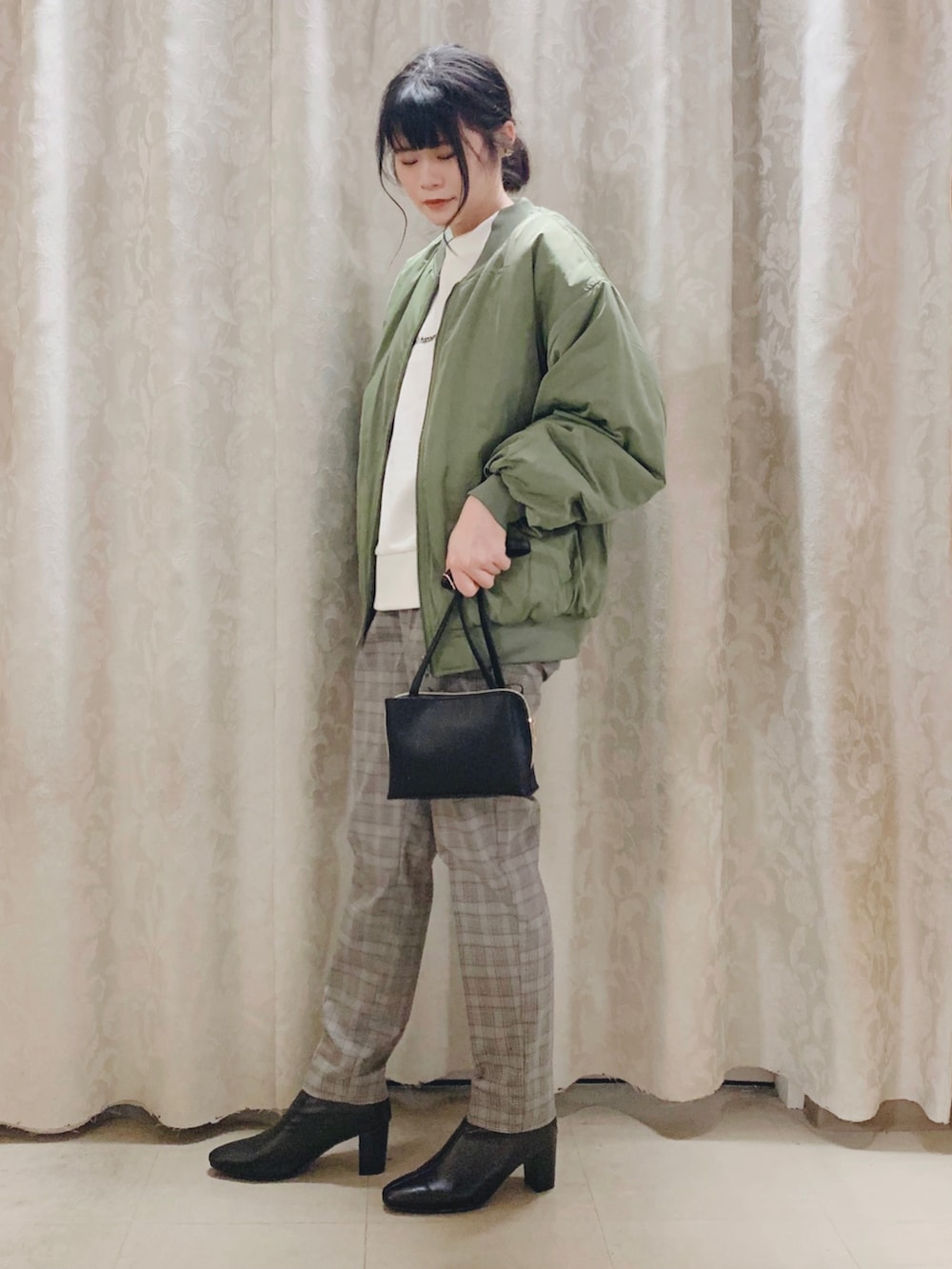 グリーン系のブルゾン、ベージュ系のスウェット、グレー系のその他パンツを着用したレディースの秋コーディネートの2枚目の写真